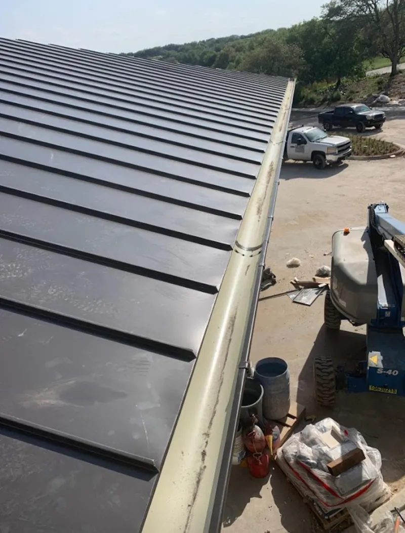 Standing seam panel and gutter detail on a metal roofing jobsite in Darlington